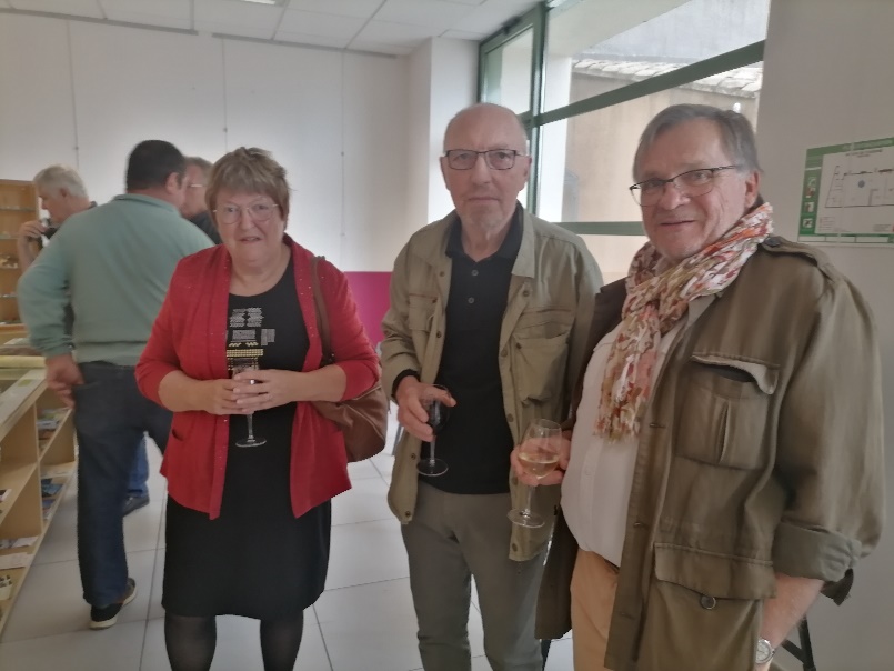 Trois personnes debout un verre à la main