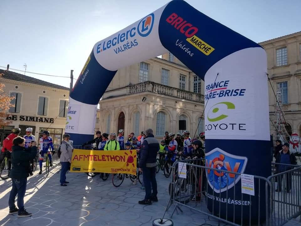 Plusieurs cyclistes sous l'arche de départ, Mairie de Valréas